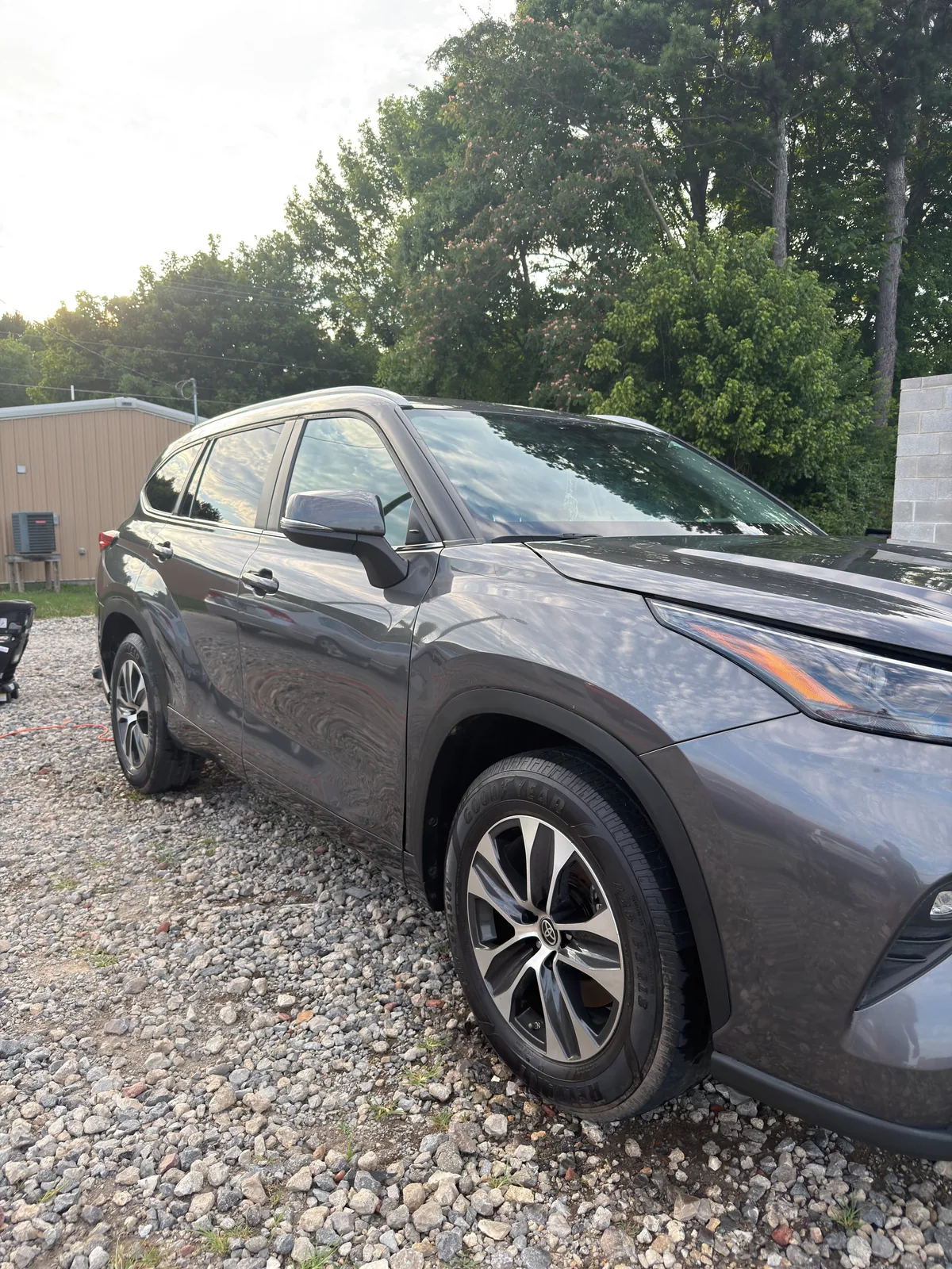 The same Toyota Highlander washed clean with the paint reflecting the tree line